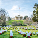 Cemetery with rows of tombstones and wreaths.