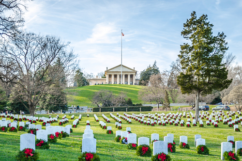 Cemetery with rows of tombstones and wreaths.