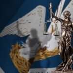 Lady Justice statue with Louisiana state flag background.