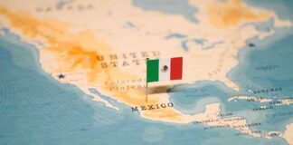 Mexican flag pin on a map of Mexico.