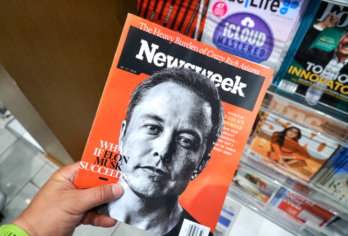 Person holding Newsweek magazine with Elon Musk cover.