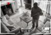 Home security footage of masked intruder with crowbar.