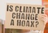 Person holding sign IS CLIMATE CHANGE A HOAX?