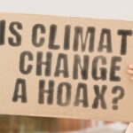 Person holding sign IS CLIMATE CHANGE A HOAX?