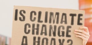 Person holding sign IS CLIMATE CHANGE A HOAX?