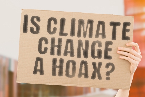 Person holding sign IS CLIMATE CHANGE A HOAX?