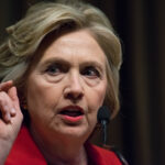 Woman speaking at a podium with microphones.