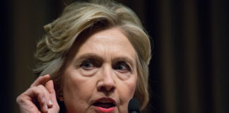 Woman speaking at a podium with microphones.