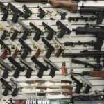 Gun display wall with various pistols and rifles.