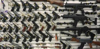 Gun display wall with various pistols and rifles.