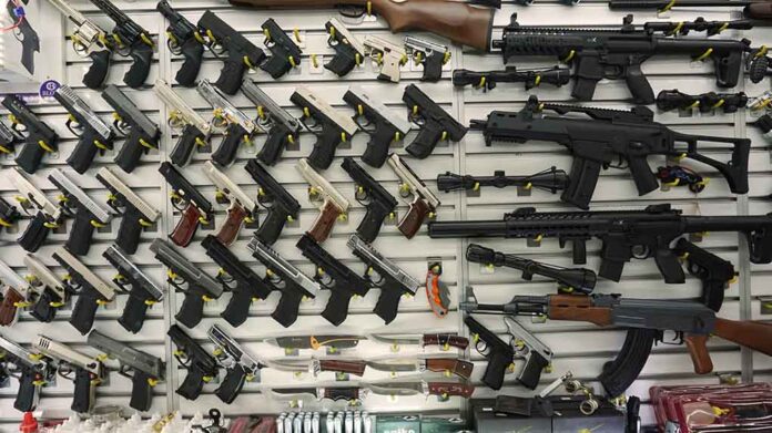 Gun display wall with various pistols and rifles.