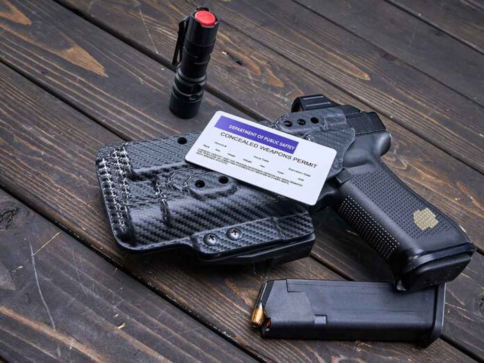 Pistol, holster, permit, flashlight, and magazine on wooden background.