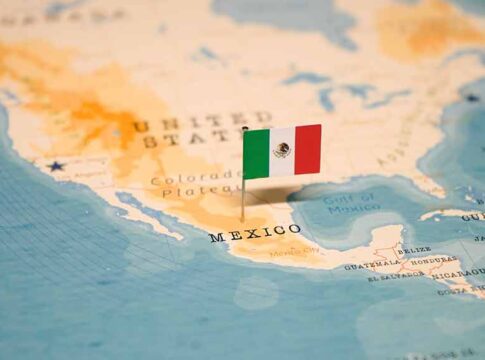 Mexican flag pin on a map of Mexico.