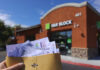 Holding tax documents outside H&R Block office.