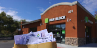 Holding tax documents outside H&R Block office.