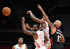 Basketball players reaching for the ball during a game.