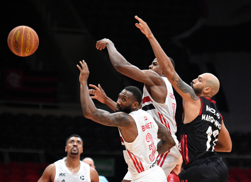 Basketball players reaching for the ball during a game.