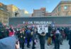 Protestors with anti-Trudeau signs in a snowy urban setting.