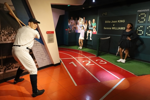 Wax figures of famous athletes in sports-themed museum display.