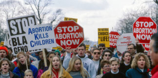 Protesters holding anti-abortion signs at a rally.