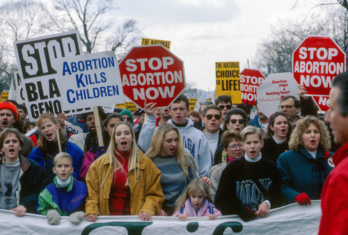 Protesters holding anti-abortion signs at a rally.