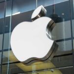 Large Apple logo on glass building facade.