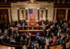 Large group in U.S. Congress chamber, American flag displayed.