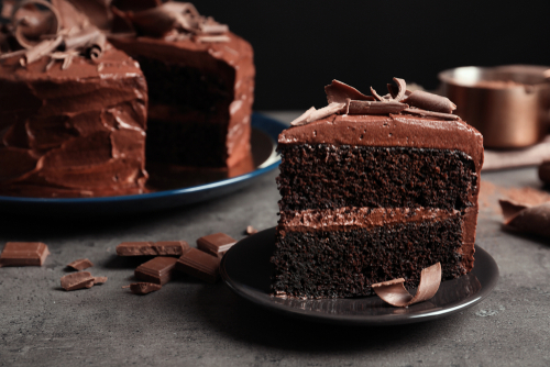 Chocolate cake slice on dark gray plate.