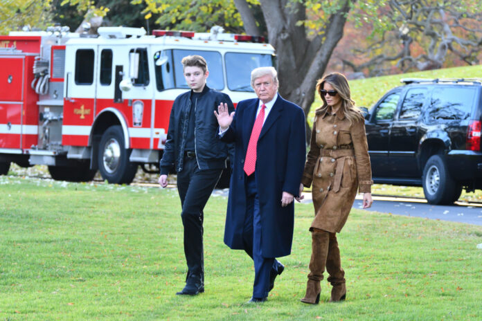 Three people walking outside near emergency vehicles