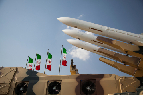 Missiles on launchers beside Iranian flags.