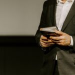 Person in suit holding a Bible.