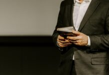 Person in suit holding a Bible.