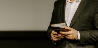 Person in suit holding a Bible.