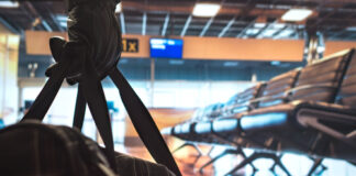 Empty airport terminal with empty seats and a backpack.