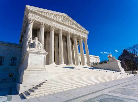 Supreme Court building with columns and statues.