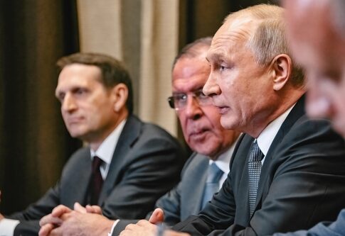 Four men in suits at a conference table.