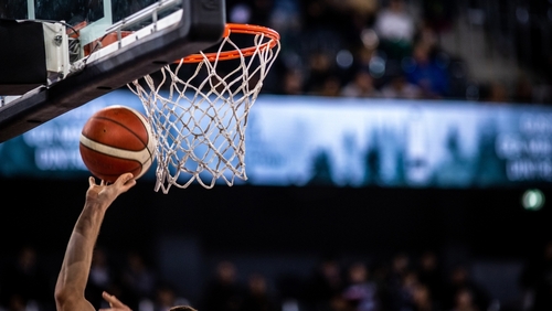 shutterstock_2245335375.jpg A basketball player reaching for the hoop with a ball