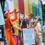 Pride Clash: Who Really Fueled Boston’s OUTBREAK? People celebrating at Pride parade, holding signs and flags.