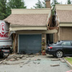 Truck crashed into house with damaged garage and car