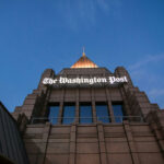 Bezos Pulls PLUG on WaPo’s Woke Agenda The Washington Post building against a twilight sky.