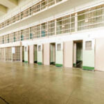 Empty prison cells in a hallway.