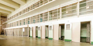 Empty prison cells in a hallway.