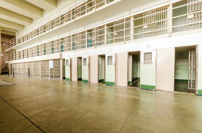 206092135-1 Empty prison cells in a hallway.