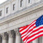 Six‑Figure Visa Fee on Ice—For Now United States courthouse with American flag waving.
