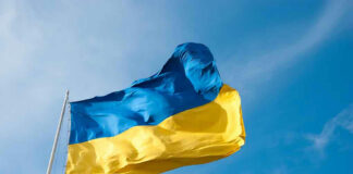 Ukrainian flag waving against blue sky.