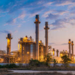 Industrial plant with smokestacks at dusk.