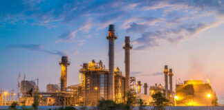 Industrial plant with smokestacks at dusk.