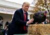 DOJ Walks, Tape Still Hides A man in a suit interacting with a turkey during a Thanksgiving pardon ceremony