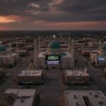 Aerial view of a mosque complex at sunset with surrounding buildings