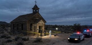 Police and forensic team at a crime scene near an abandoned church in the desert